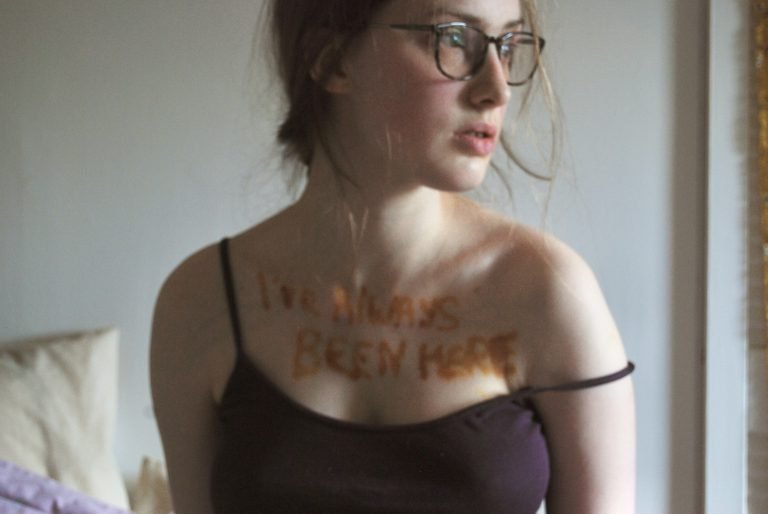 A young white woman looks to the side of the frame.