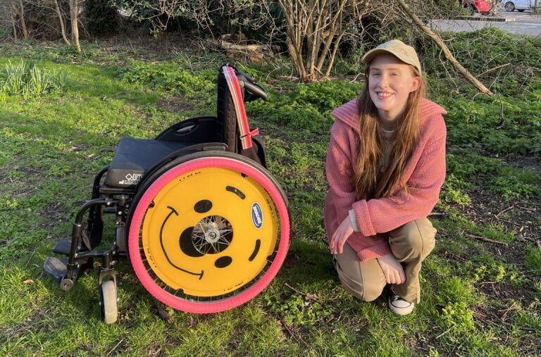 Sakara crouched by her wheelchair